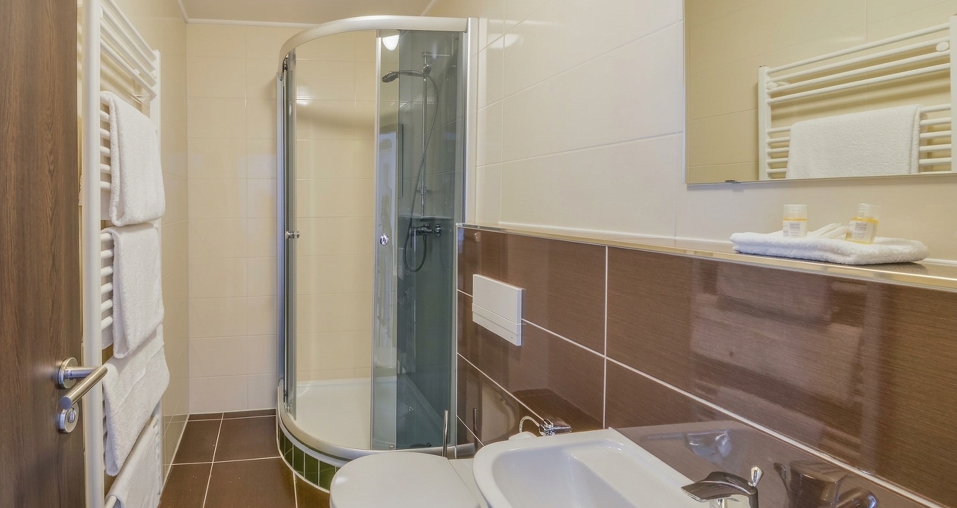 Modernes Ensuite-Badezimmer mit Runddusche und flauschigen Handtüchern